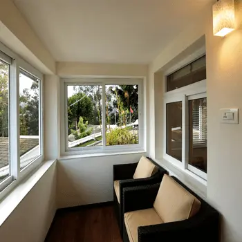Window-lined sitting area with chairs overlooking the garden