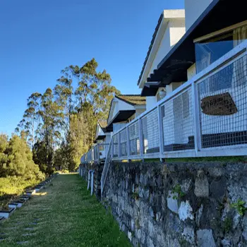 Cottage balconies above a stone wall beside the lawn