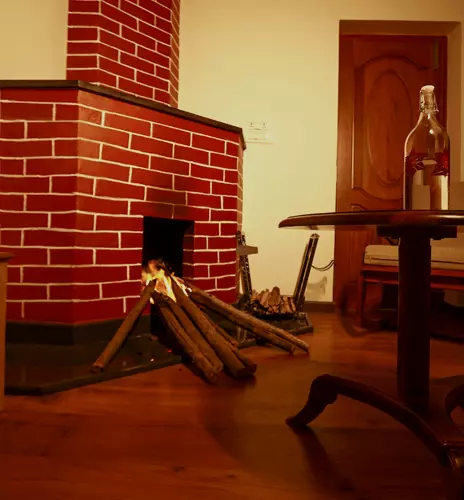 Indoor brick fireplace beside wooden seating