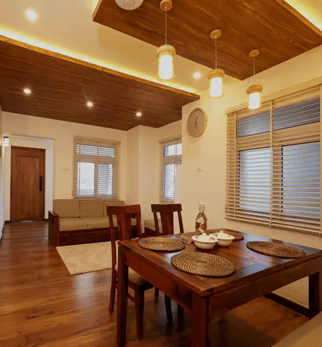 Wooden dining table and chairs beneath a wood-panelled ceiling