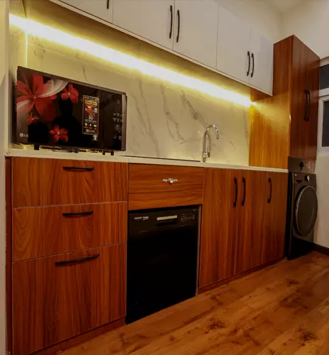 Kitchen counter with wooden cabinets, an oven and a microwave